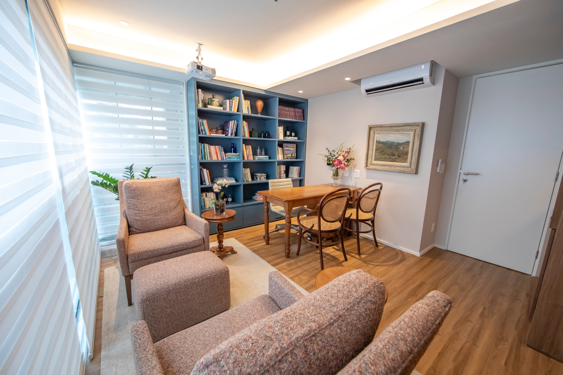Sala de atendimento com poltronas e biblioteca
